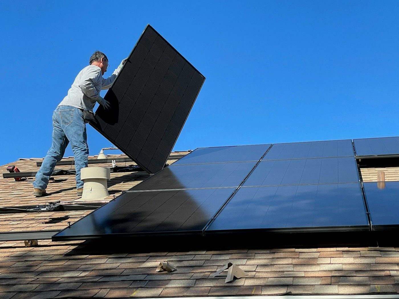 Installer placing a solar panel on a roof