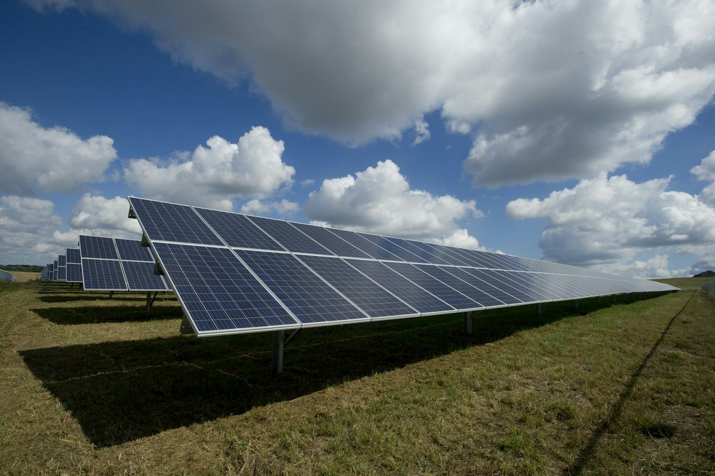 Rows of solar panels under a cloudy sky